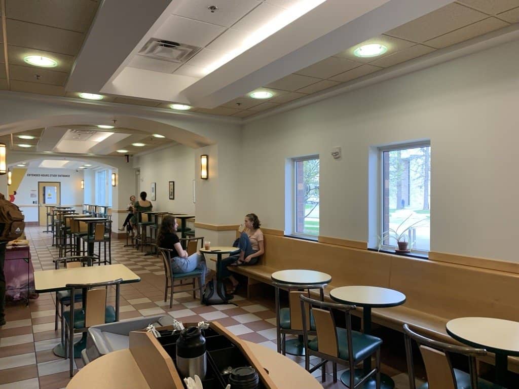 a group of people sitting at tables in a cafeteria