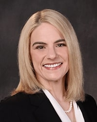 Megan MacPherson portrait showing head and shoulders, smiling, on a gray background