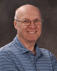Thomas Gilsdorf portrait showing head and shoulders, smiling, on a gray background