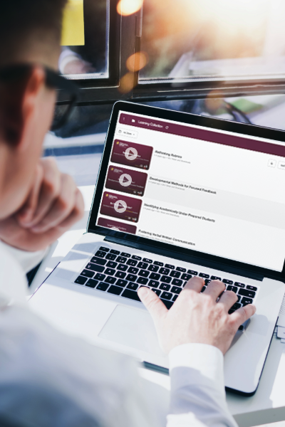 A person looking at their laptop screen which is displaying a list of videos