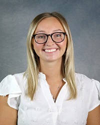 Woman smiling wearing white shirt.