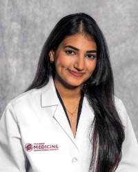 Marwa Khalil in a white lab coat with the CMU College of Medicine logo.