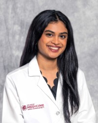 Umme Aiman Mirza in a white lab coat with the CMU College of Medicine logo.