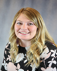 Headshot of Cassandra Ross wearing a multicolor print top.