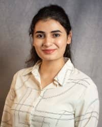 A woman wearing a white and black patterned button-down.