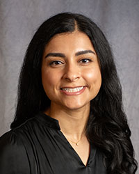 Elham Aldosari has long dark hair and is wearing a black blouse.