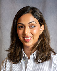 Hana Malik is wearing a striped, button down shirt.