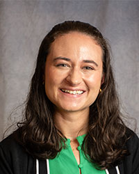 Alissa Roemer is wearing a black cardigan and a green blouse.