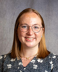 Abigail Struble is wearing glasses and a floral print blouse.