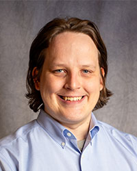 Anthony Vicini is wearing a blue shirt, smiling for a picture