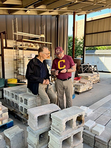 Ceramics professor, Israel Davis gave the Thompsons a tour of the ceramics facilities, including the new construction of kilns.