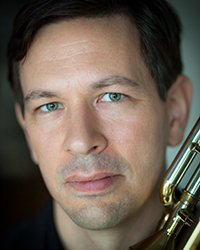 Headshot of George Curran on a soft grey backdrop.