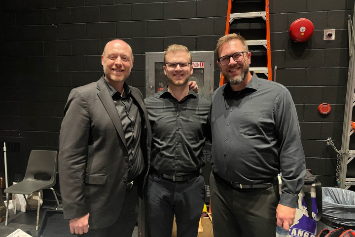 a group of men standing together smiling in concert black