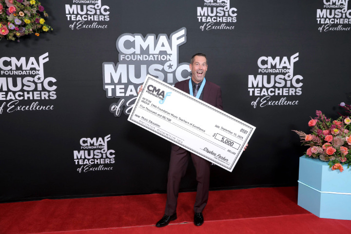 a man holding a large check with a large smile on his face