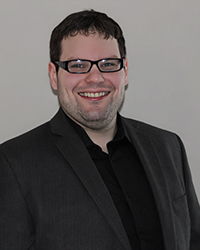 Headshot of Jason Dizik with a grey backdrop.