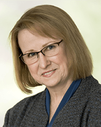 Headshot of Sarah Opperman with a white and gold backdrop.