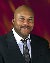 Headshot of Terry Foster, He is speaking into a microphone.