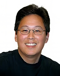 Headshot of Wayne Kamidoi on a white backdrop.