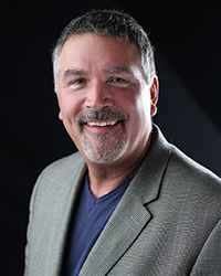Headshot of Tim Roberts in front of a black backdrop.