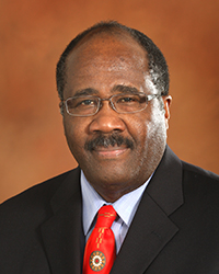 Headshot of Rick Sykes in front of a tan backdrop.