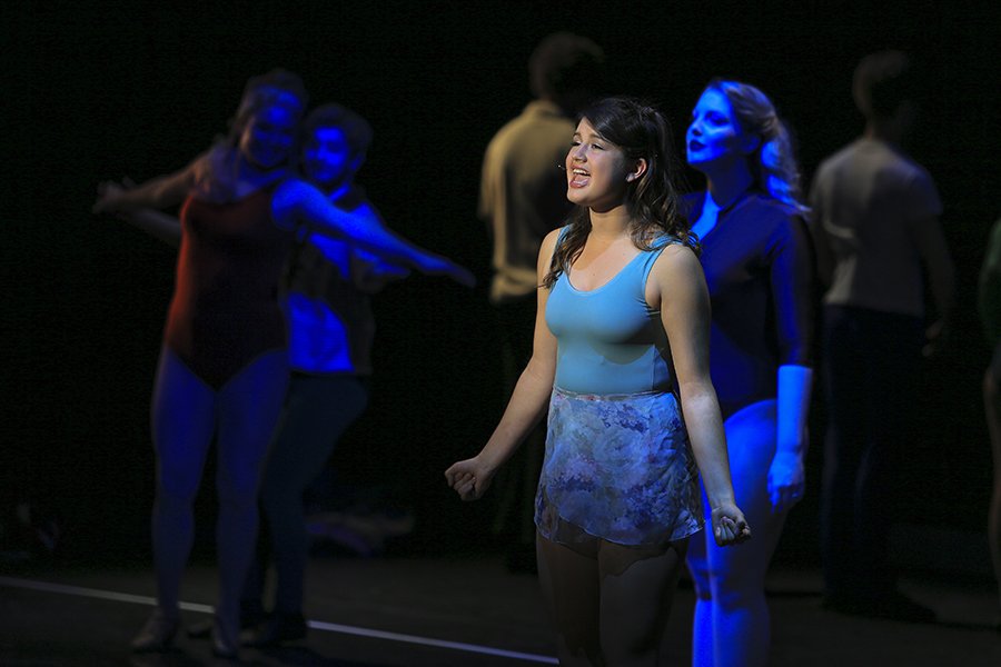Multiple students singing in a musical theatre production