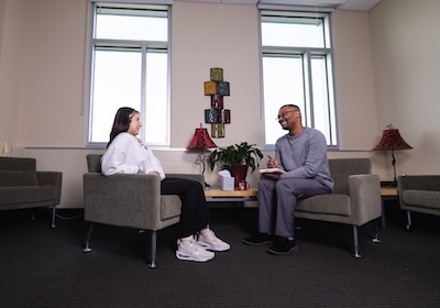 A counselor sitting and smiling with a patient in a counseling office.