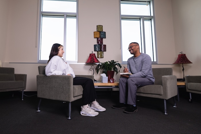 A counselor sitting with a patient in a counseling office.