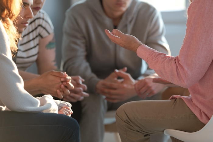 A group of people sitting in a circle at a counseling session.