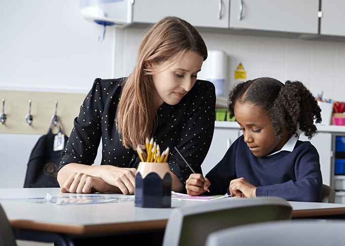 Teacher working with a young student in a classroom