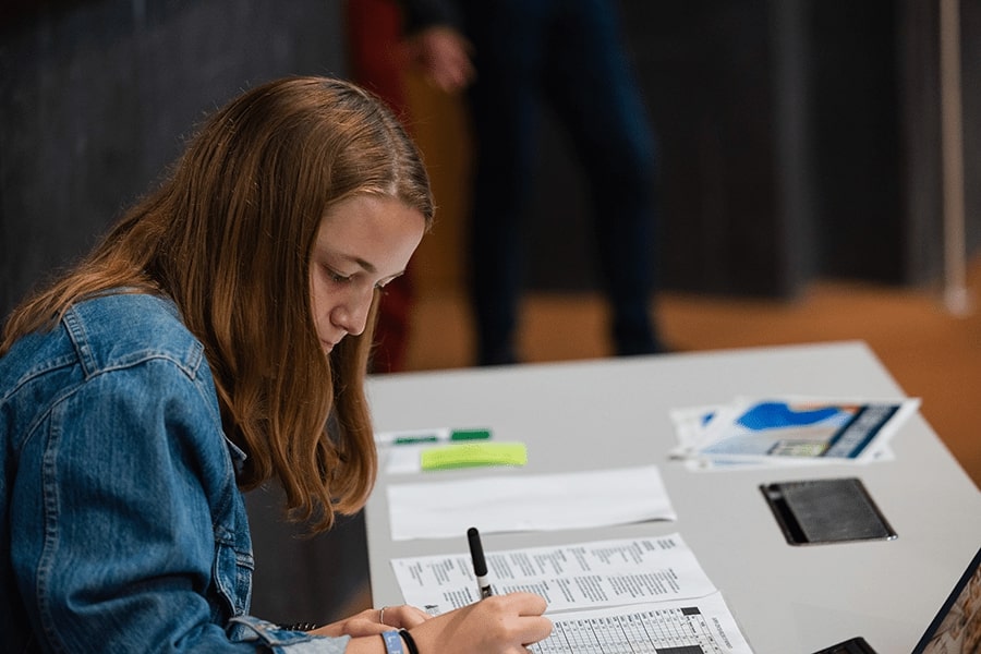 Student filling out document during poverty simulation.