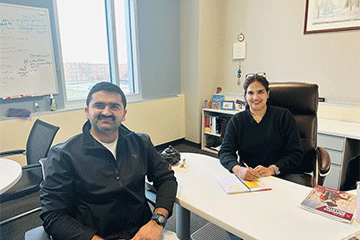 A Master of Science in Administration student and the Assistant Director sit together at a table.