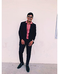Vimal Nair- MSA Peer Mentor, standing outside against a white building while smiling for a photo.
