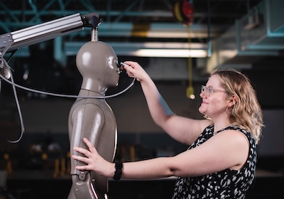 Lauren Agnew plugging in a cord to the adult manikin, Norman.