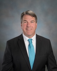Professional headshot of Jeffrey Collier against a grey background.