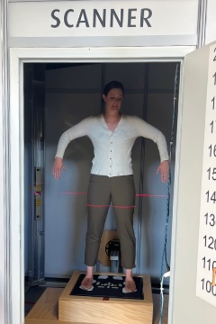 A person standing inside the body scanner at the CMDT lab.