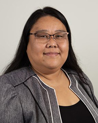 Closeup image of Hanako Wakatsuki-Chong wearing a grey suit and black shirt