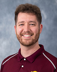 Closeup image of Adam Gepford wearing a maroon shirt