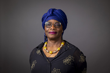 Closeup image of English faculty member Maureen Eke wearing dark shirt with yellow flowers.