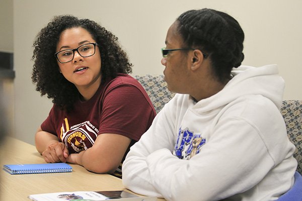 Two students sit next to each other at a table during a dialogue facilitator training