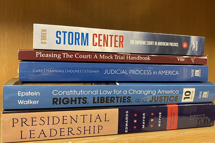 Law and leadership books stacked on a table.