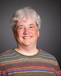Anja Mueller in a striped sweater smiling at the camera.