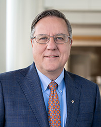 A man in a suit and tie wearing glasses.