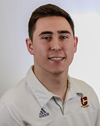 20250904_GavinKelly_200x250 a man with short dark hair in a white CMU shirt smiling for a photo