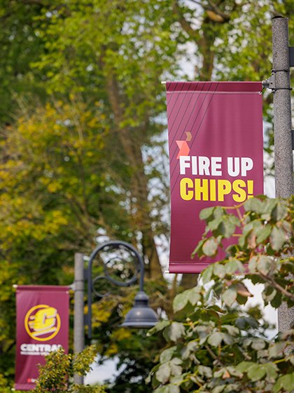 A Fire up, Chips! banner hangs from a light post on campus