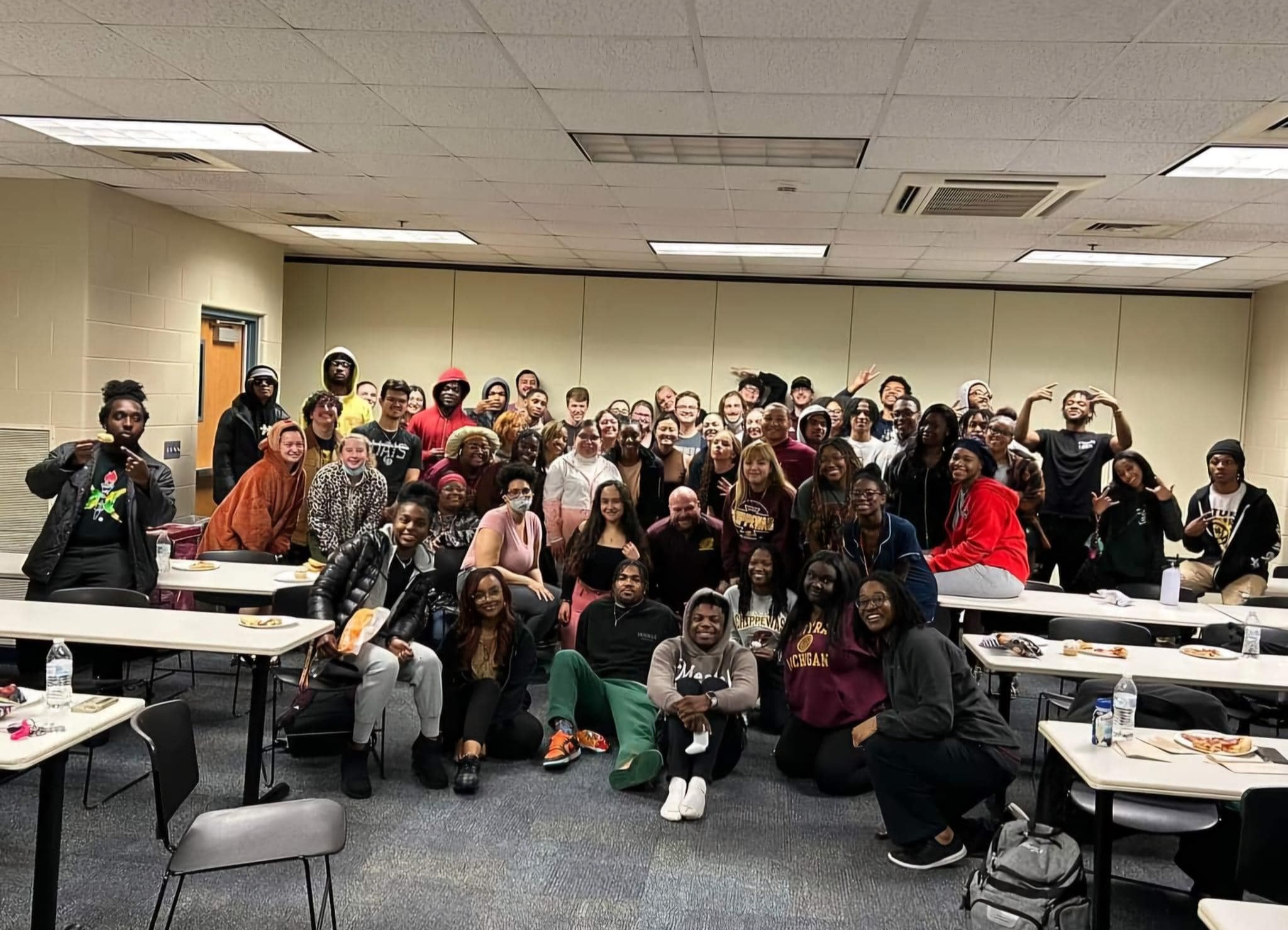 movienight Many students gather in the towers meeting room to play xbox video games with officer josh chapman. They are in a rather large room with bright lighting.