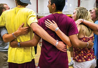 CMU students in a circle with their arms around each other
