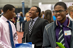 Two black men in business attire talk at a career fair