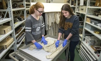 Students carefully handle clothing in the Museum collections