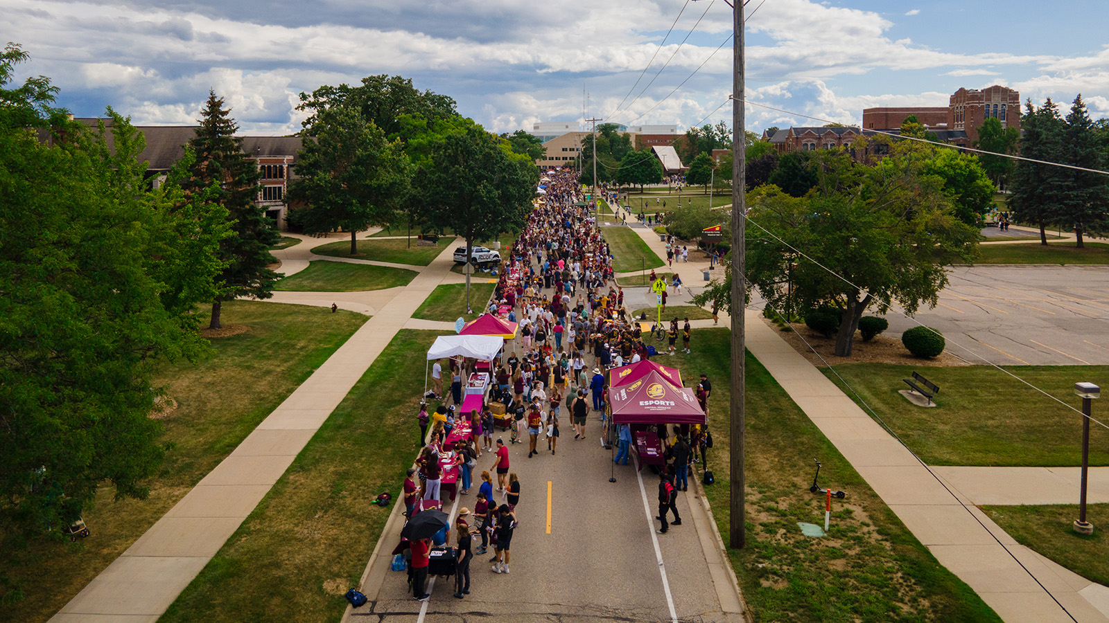 An aerial shot of hundreds of group of people walking down the middle of a street
