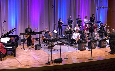 A group of people playing instruments on a stage.
